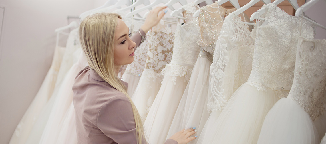 Beautiful girl chooses her wedding dress. Young woman entrepreneur. Portrait in Bridal salon